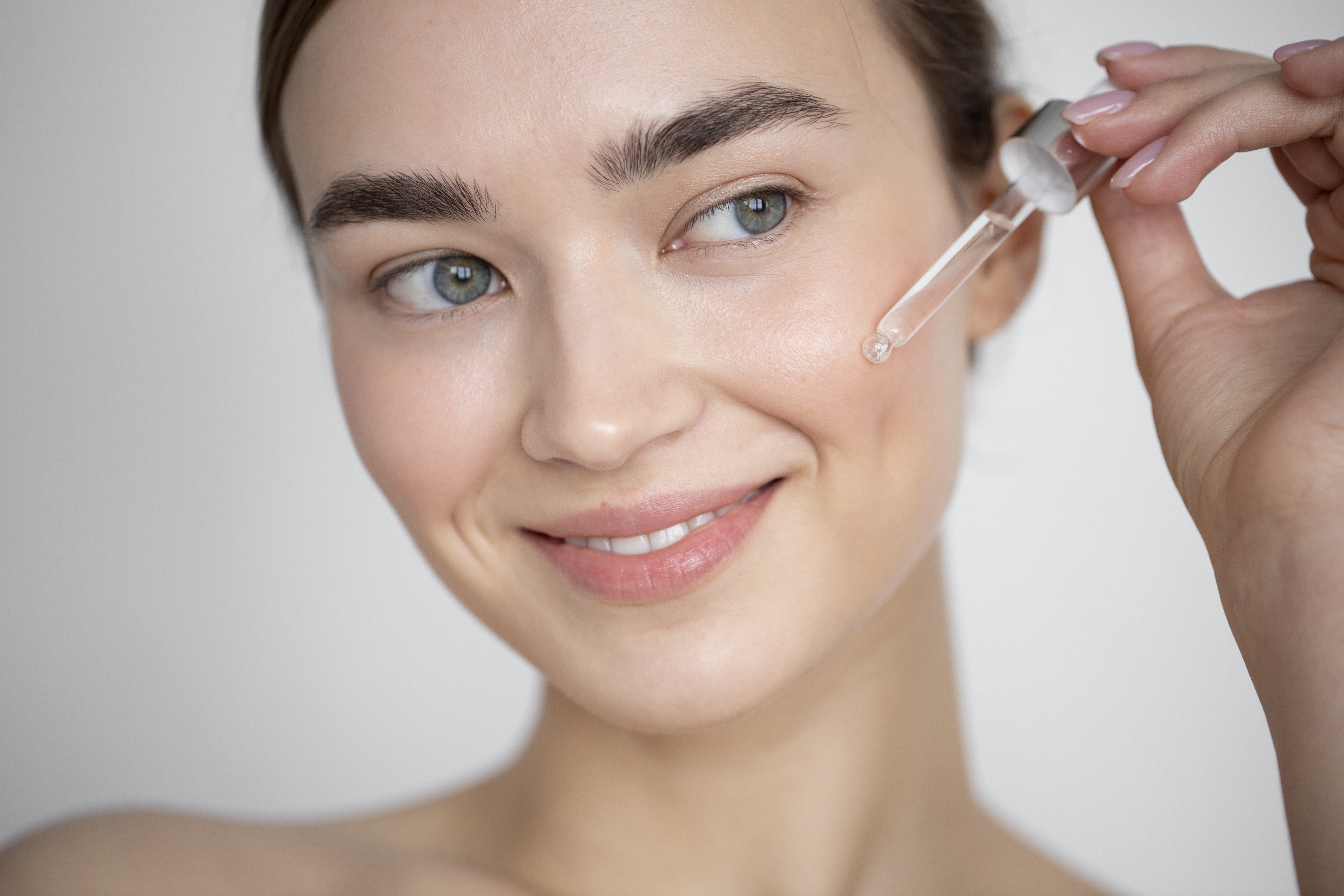 portrait-beautiful-woman-with-clear-skin-using-face-serum